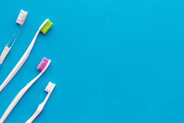 Daily oral hygiene for family. Toothbrush on blue background top view mock up