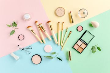 Professional decorative cosmetics and makeup tools brushes on colorful background. Beauty and fashion concept. Flat lay composition. Top view.