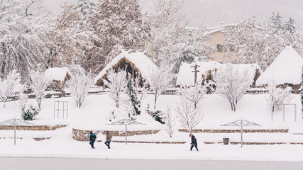 people running in snow - winter landscape with old houses