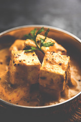 Malai or achari Paneer in a gravy made using Whipping Cream. served on a serving pan. selective focus