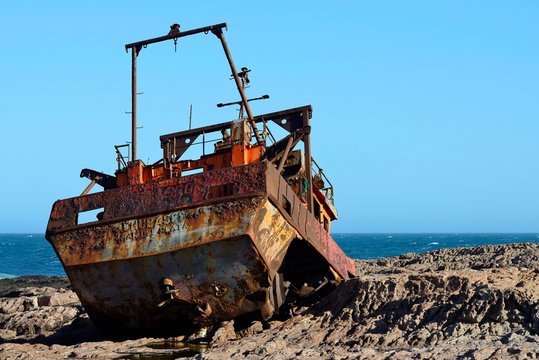 Rusty wreck of a fish trawler on the rocky shore, Cabo Raso, near Camarones, Chubut, Argentina, South America