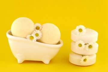 Chamomile essential  soap and bath bombs with chamomile extract on a bright yellow background.set of cosmetics for the body with chamomile extract