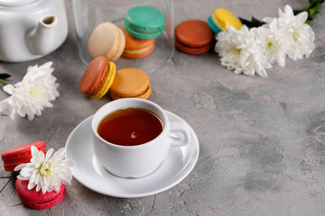 Obraz na płótnie Canvas Provence breakfast. Bright french macarons , a cup of tea, a teapot. Grey background.