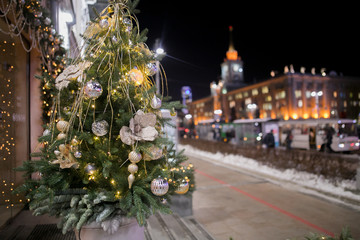 Decorated christmas tree near store window. Shallow depth of field