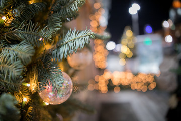 Decorated christmas tree near store window. Shallow depth of field