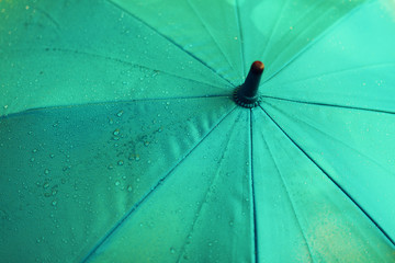 Blue umbrella with rain drops. Autumn weather concept