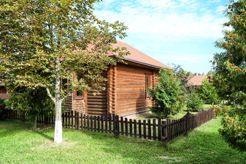 Fototapeta na wymiar Small wooden house in garden with trees on a summer day