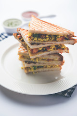 Paneer bhurji sandwich is a tasty paneer based dish made with cottage cheese.served with fresh tomato ketchup and green mint chutney. selective focus