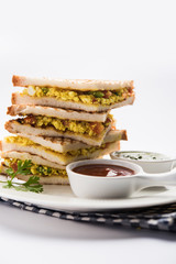 Paneer bhurji sandwich is a tasty paneer based dish made with cottage cheese.served with fresh tomato ketchup and green mint chutney. selective focus