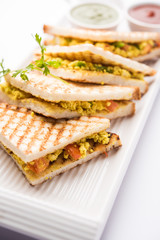 Paneer bhurji sandwich is a tasty paneer based dish made with cottage cheese.served with fresh tomato ketchup and green mint chutney. selective focus