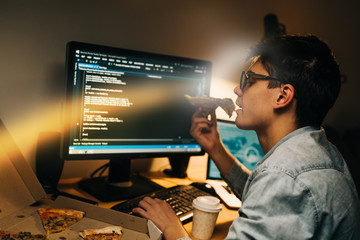 teenager hacker working late on computer at his apartment