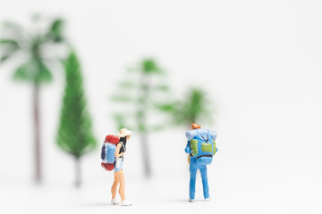 Miniature people : Traveler with backpack walking on whitebackground ,
