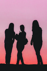 silhouettes of three girls taking a selfie 