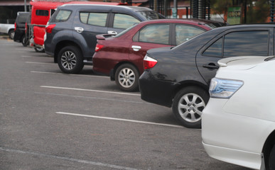 Closeup of rear side of white car parking in parking lot at twilight evening. 