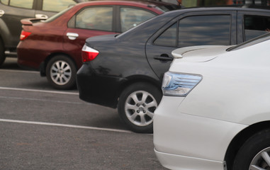 Closeup of rear side of white car parking in parking lot.