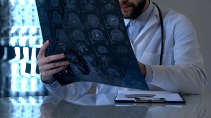 Oncologist examining brain x-ray in laboratory, cancer treatment, health care