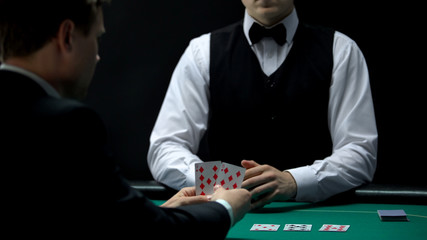 Casino businessman client gets bad hand from house croupier, poker gambling