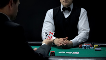 Upset businessman having bad cards combination in poker, weak hand casino wins