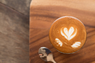 Piccolo Latte art in small glass on wooden desk