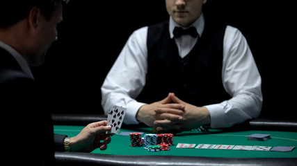 Overconfident businessman having bad hand combination but making bet at poker