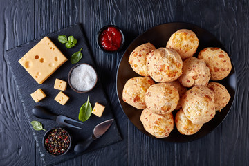 Gougeres, cheese puffs balls on a black plate