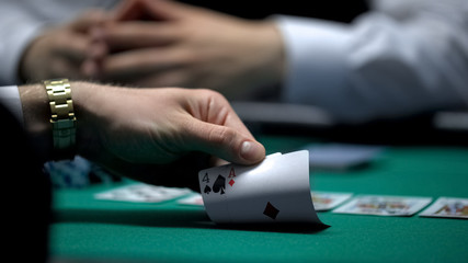 Unfortunate poker game, hand of casino player checking bad card combination