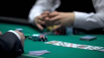 Casino croupier waiting for poker player to reveal cards combination, gambling