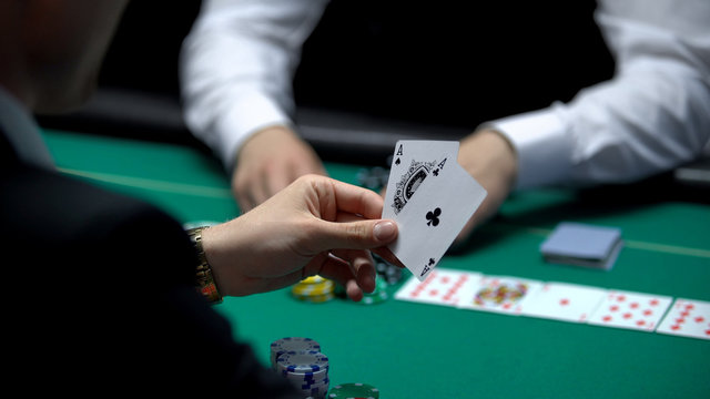 Businessman player has winning cards combination during poker game, two aces