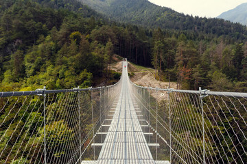 Fototapeta na wymiar Suspension bridge in the mountains near the village of Perarollo di Cadore.