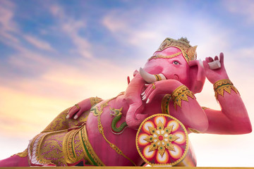 A large statue of pink Ganesha is god of Hindu which one of the best-known and most worshipped deities in the Hindu pantheon, at twilight time on background.
