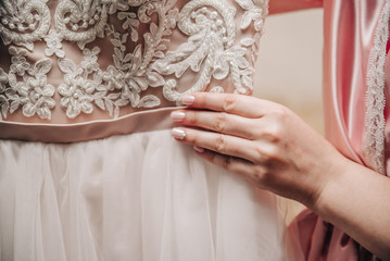 young girl with a beautiful manicure holding a wedding dress