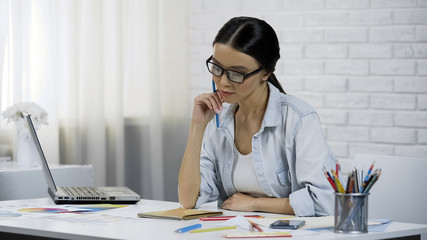 Woman designer thinking over project, remote working at home, stylist of clothes