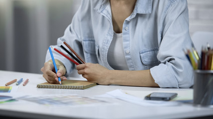 Young woman designing interior, freelancer doing work, coloring with pencils