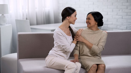 Two women happily communicating, smiling and embracing, trust in relationship