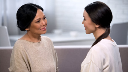 Mother talking to daughter, tenderly looking at her, giving advice, motherhood