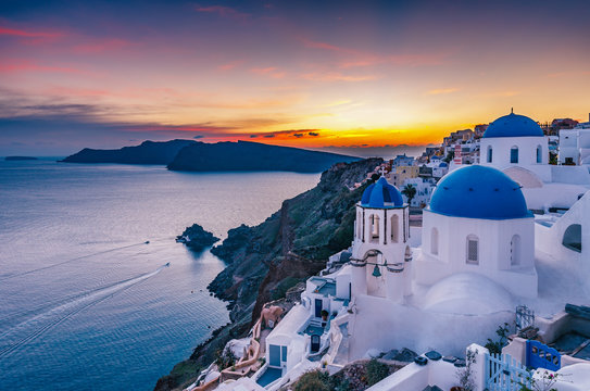 Fototapeta Beautiful view of Churches in Oia village, Santorini island in Greece at sunset, with dramatic sky.