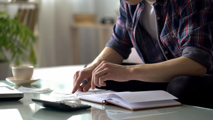 Man checking purchases, holding bill, calculating income and expenses, budget