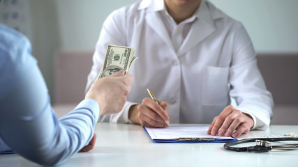 Patient holding money, paying doctor for treatment, private clinic, insurance