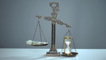 Sandglass outweighs dollars on scales, time is money, valuable resources usage