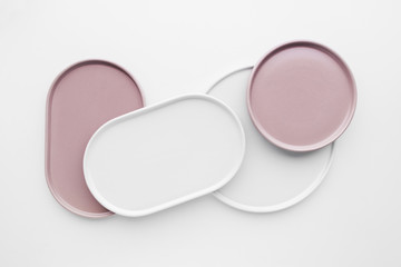 Empty pink and white ceramic plates on a white background, creative flat lay minimal tableware