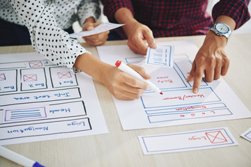 Hands of project managers working on interface design