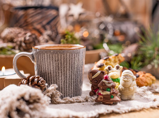 Fragrant coffee, chocolates in the form of Christmas figures. Cookies and hot drink for the holiday. Cozy atmosphere, candles decor. free space for text.