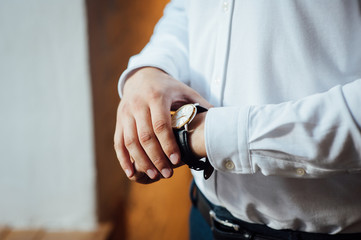 The man in the white shirt in the window wears watches