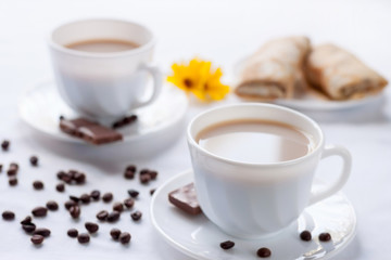 Two cup of coffee, pancakes with jam and milk chocolate. Morning breakfast for two.