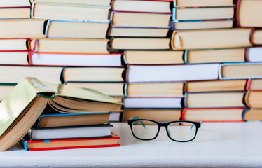 Books background, glasses and open book on white wooden table