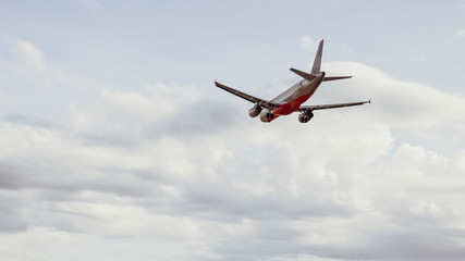 Airplane in the cloudy sky flies away . copy space for text