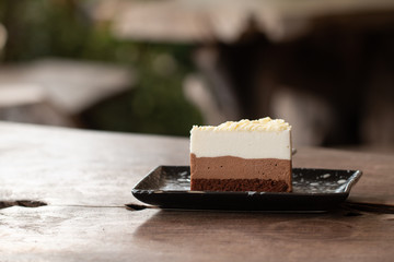Piece of delicious cheesecake on wooden desk