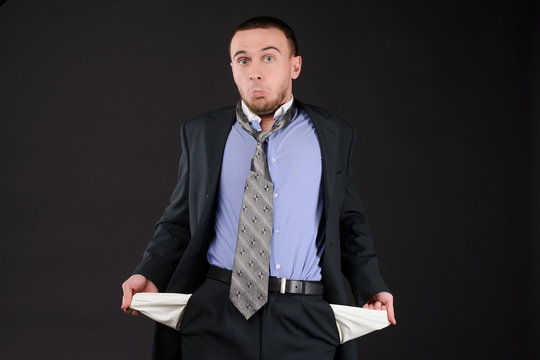 businessman turning his empty pockets inside out after tax audit or collector visit. Concept of bankruptcy.