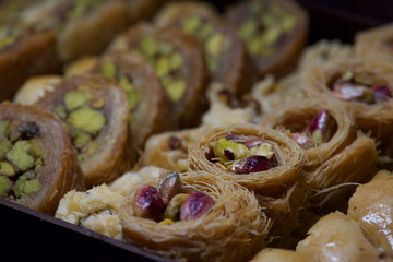Creative blurred photo of traditional pastry in Middle East country Kingdom of Jordan, traditional arabian sweet pastry baklava close up in artistic blurry background. Jordan, Middle East cuisine