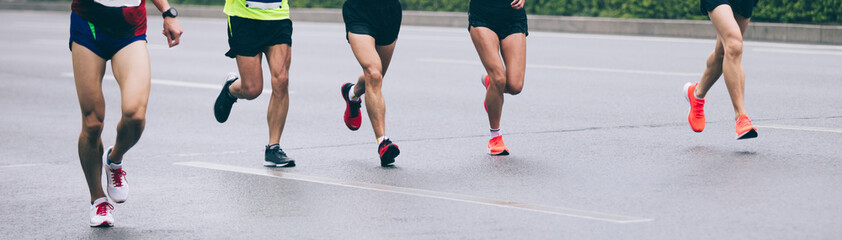 Fototapeta na wymiar Marathon runners legs running on city road